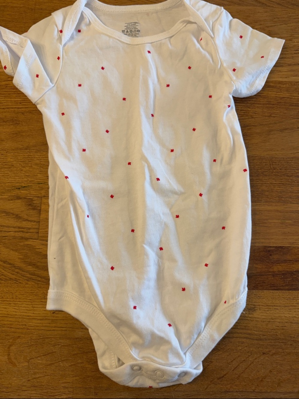 George White Baby Onesie with Small Red Maple Leafs